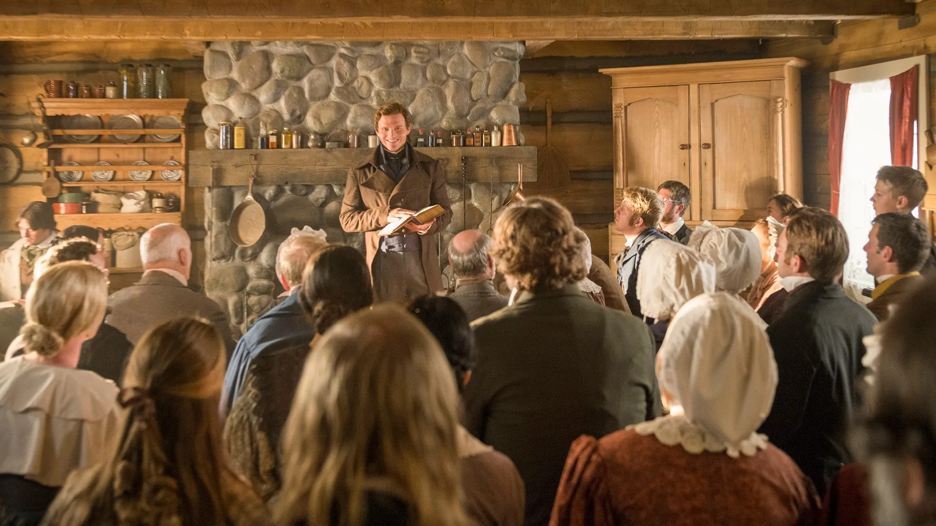 Joseph Smith stands in front of a crowd of people in the Whitmer home in this still from “A Day for the Eternities,” a film produced by The Church of Jesus Christ of Latter-day Saints.