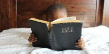 Child reading the bible. Image via pixabay